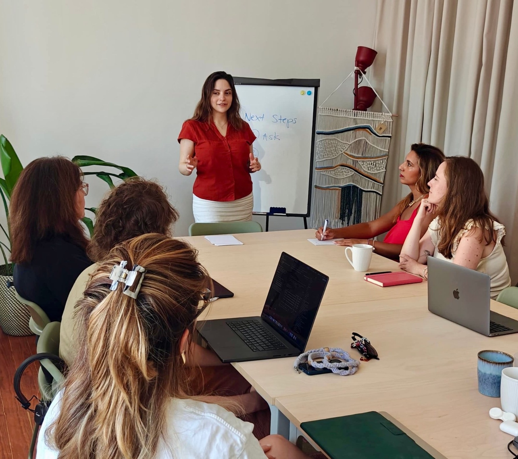 Paola Del Bosque facilitating a workshop with a multicultural team around a table