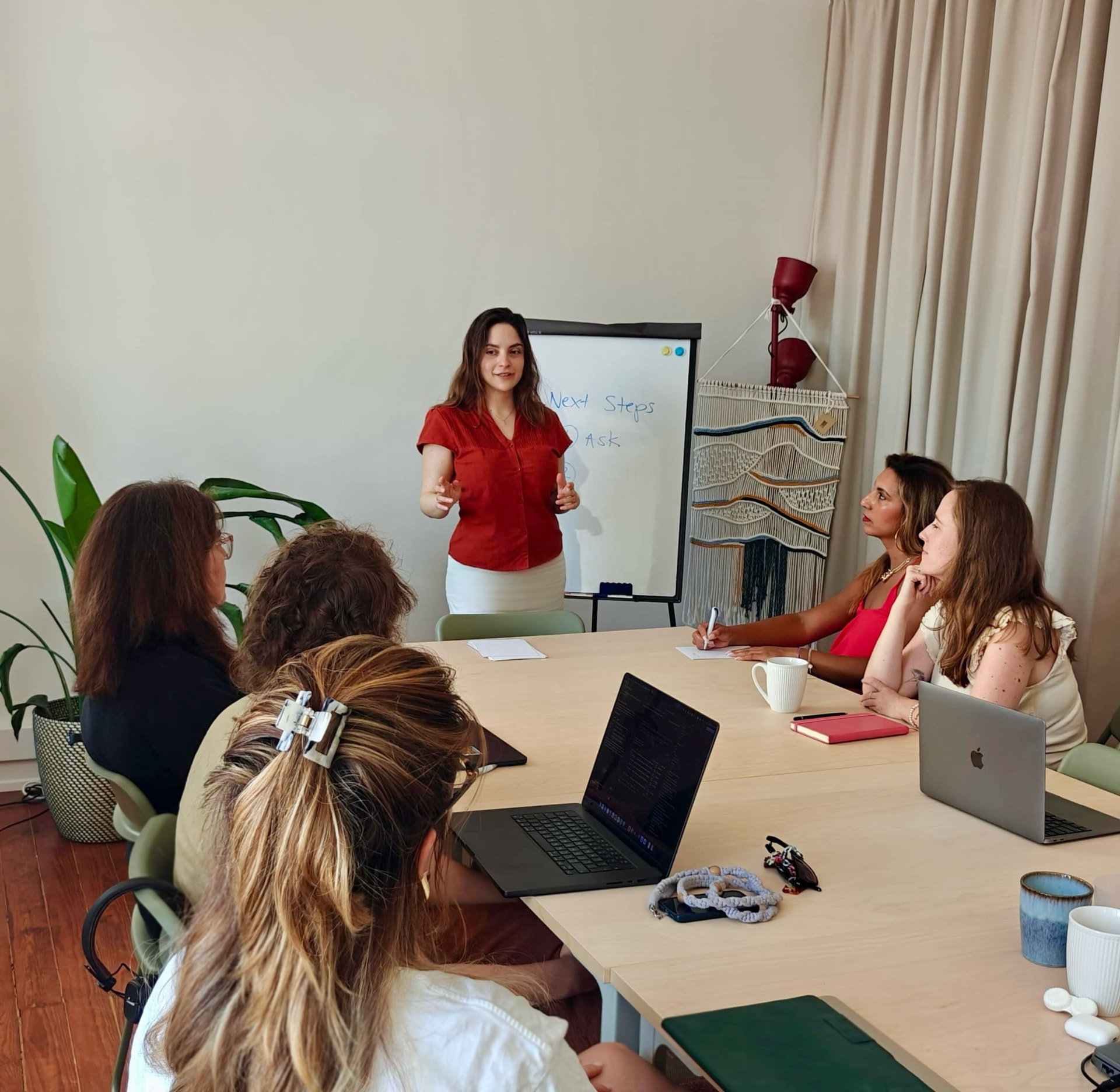 Paola Del Bosque facilitating a workshop with a multicultural team around a table